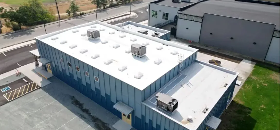 Aerial view of a commercial flat roof installed by Pressure Point Roofing